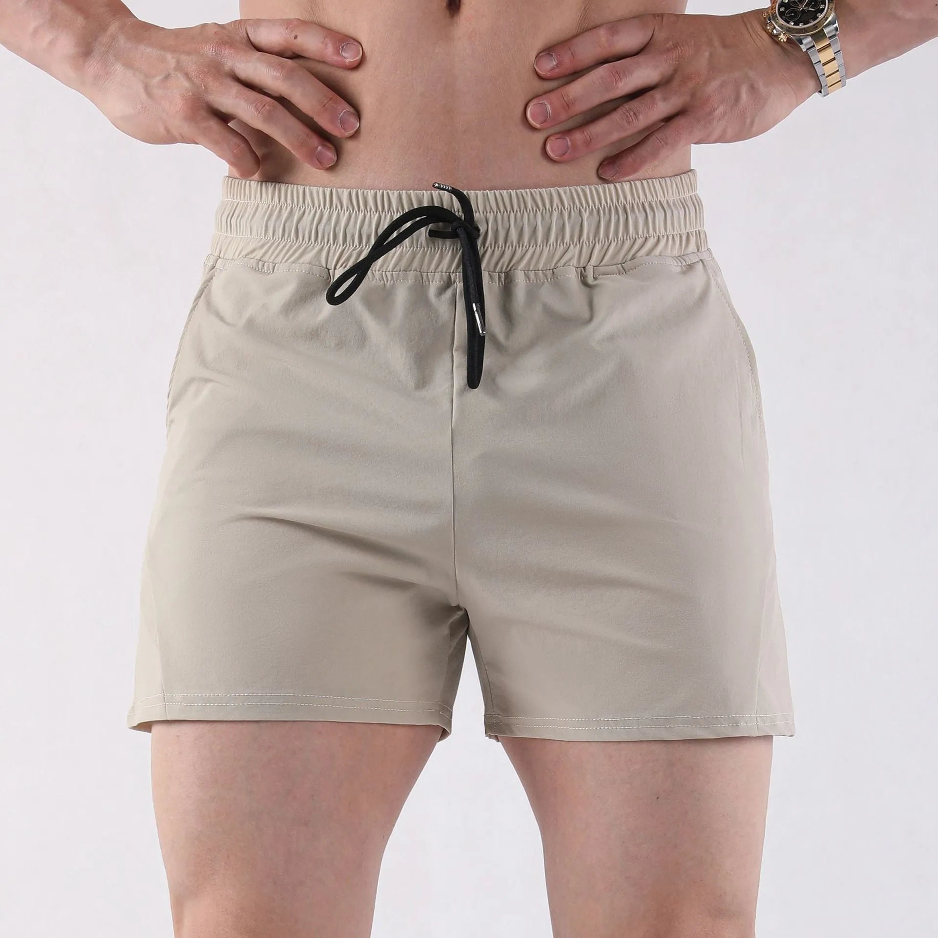 Men's thin grey polyester basketball shorts with an elastic waistband, shown in an athletic context.