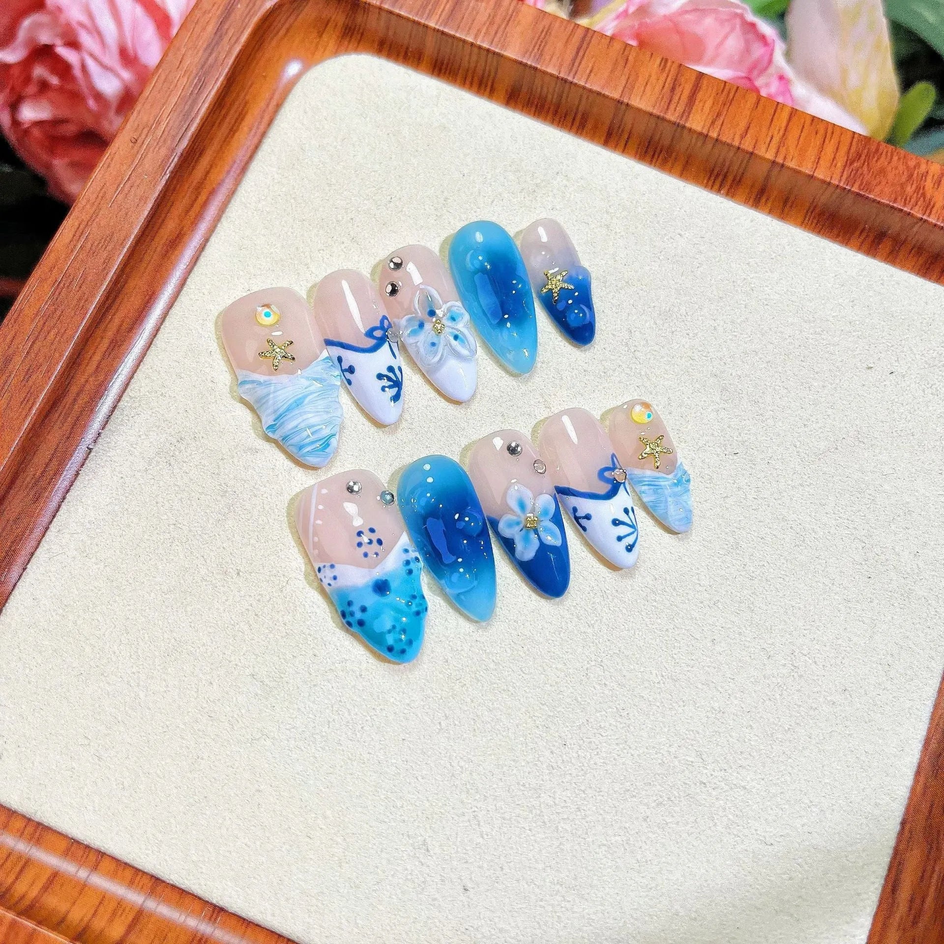 Set of blue hand-painted false nails with carved texture and a transparent summer ice aesthetic.