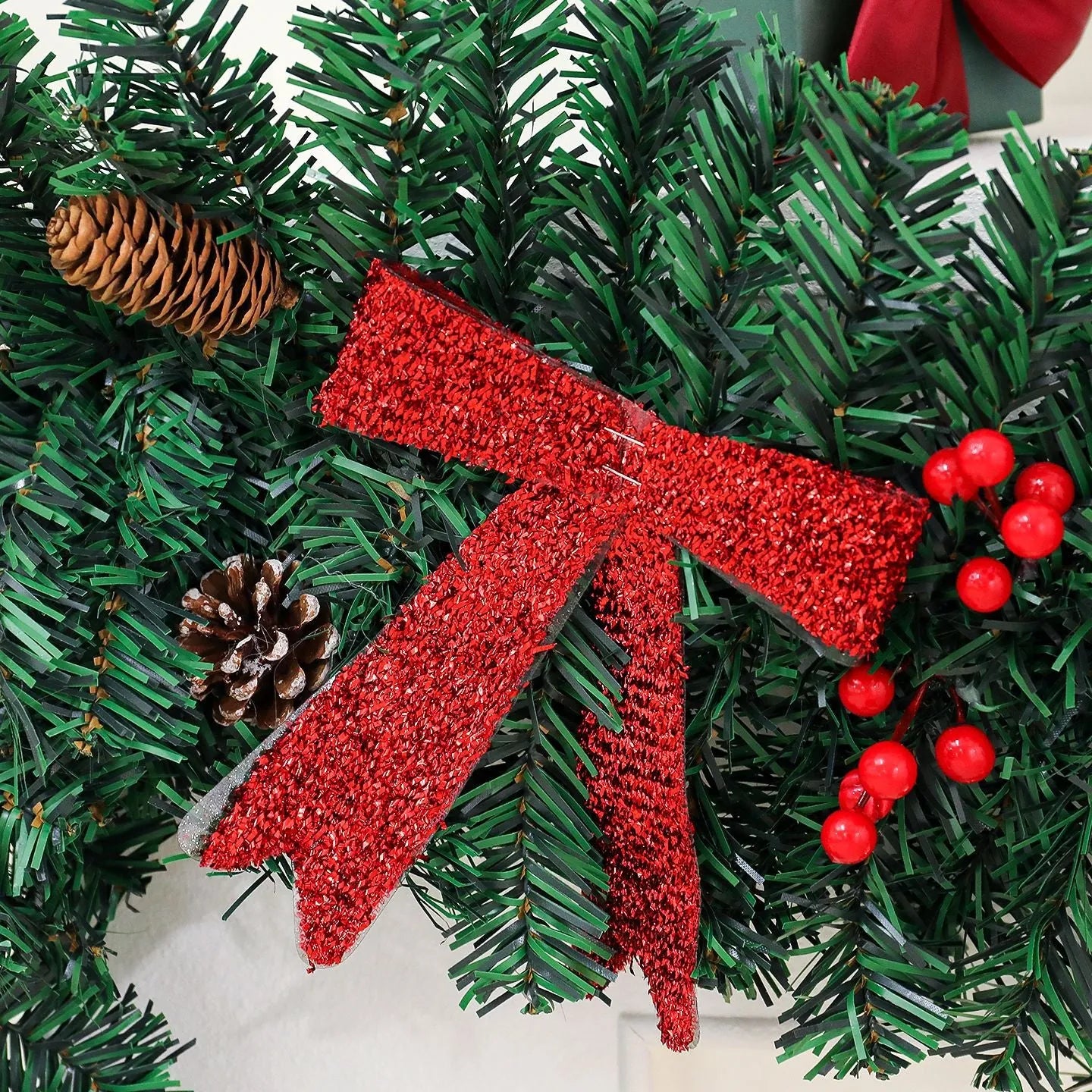 Christmas rattan decoration with PVC pine cone bow, available with optional LED lighting in warm white or coloured variants.