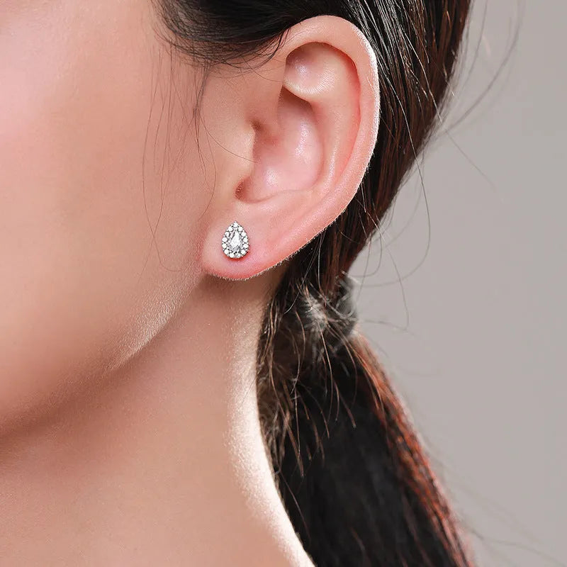 A pair of women's sterling silver water drop shaped stud earrings with a diamond-cut finish.