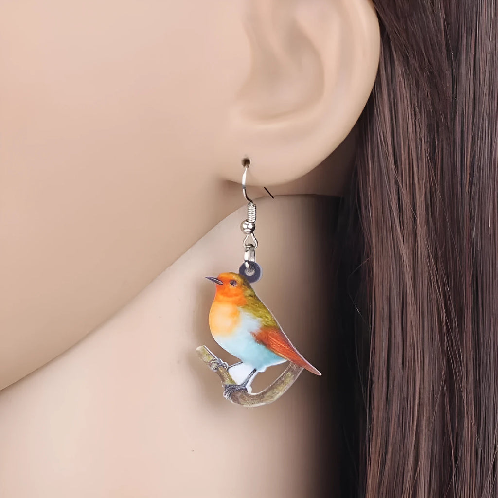 A pair of women's acrylic pendant earrings with a detailed Blue Titmouse bird design in a geometric style.