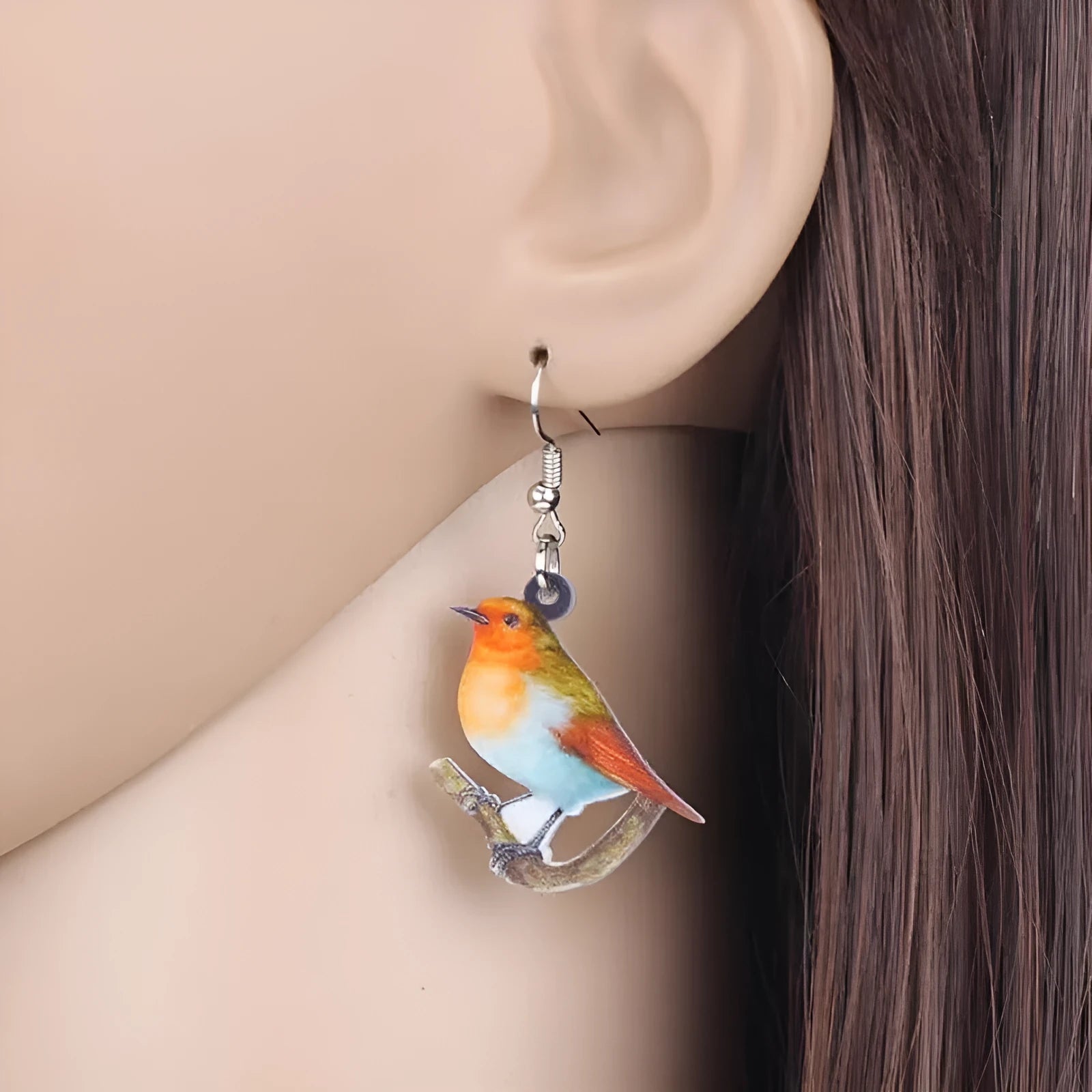 A pair of women's acrylic pendant earrings with a detailed Blue Titmouse bird design in a geometric style.