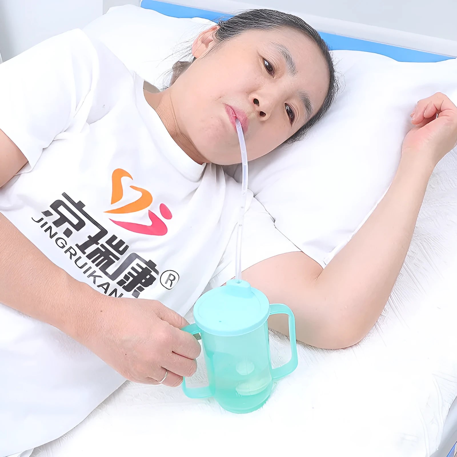 Oblique mouth choke-proof plastic drinking cup with handle and optional wrist splint for elderly adults.