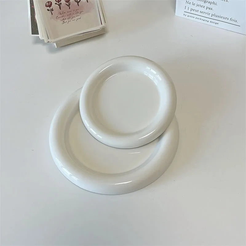 White porcelain round plate with chubby toot bear doodle pattern, shown as a plant saucer.