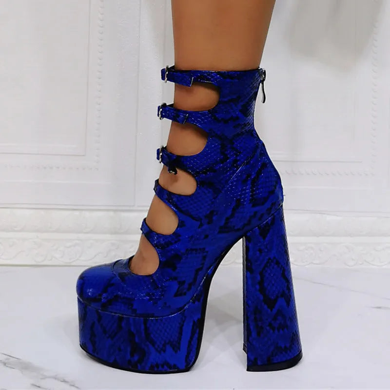 Women's black patent leather platform high heel boots with a serpentine belt buckle fastened around the ankle.