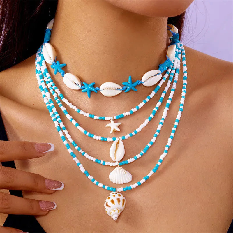Women's five-layer shell and conch bead necklace set with adjustable chain on blue background