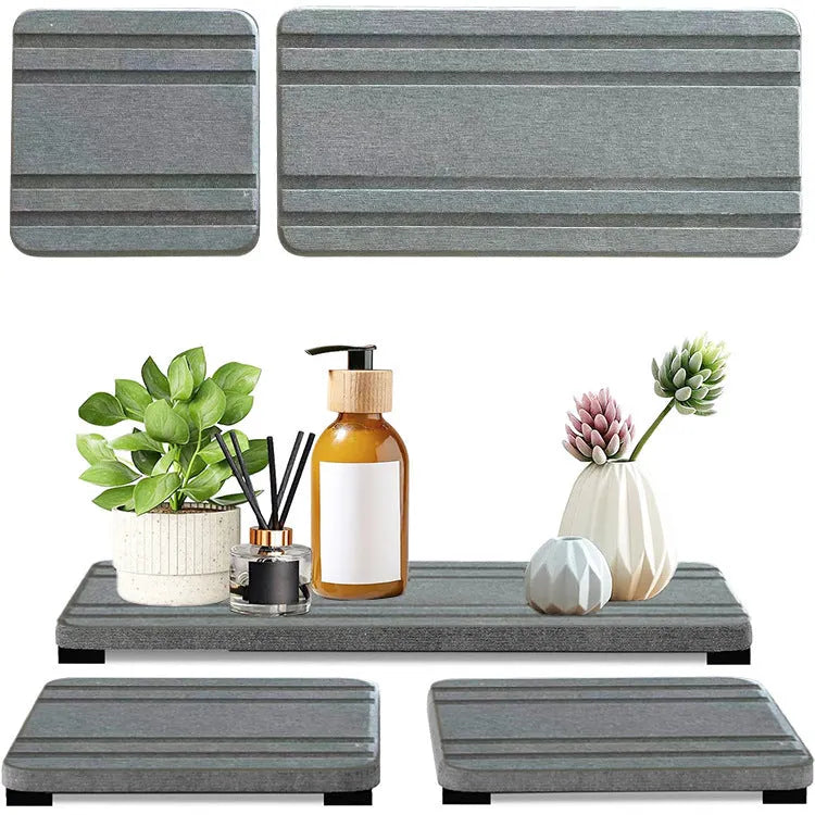 Three square diatomite bathroom draining pads in solid colours on a countertop