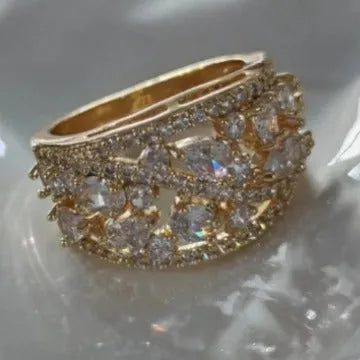 Women's hollow round fashion ring in gold or platinum finish with blue or white accents on a copper band.