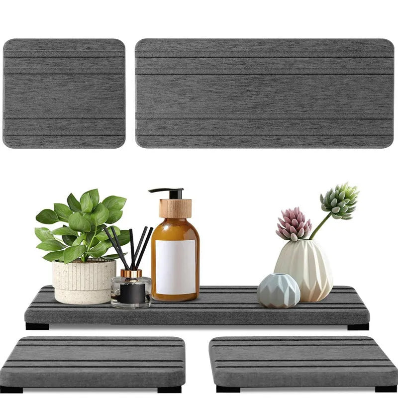 Three square diatomite bathroom draining pads in solid colours on a countertop