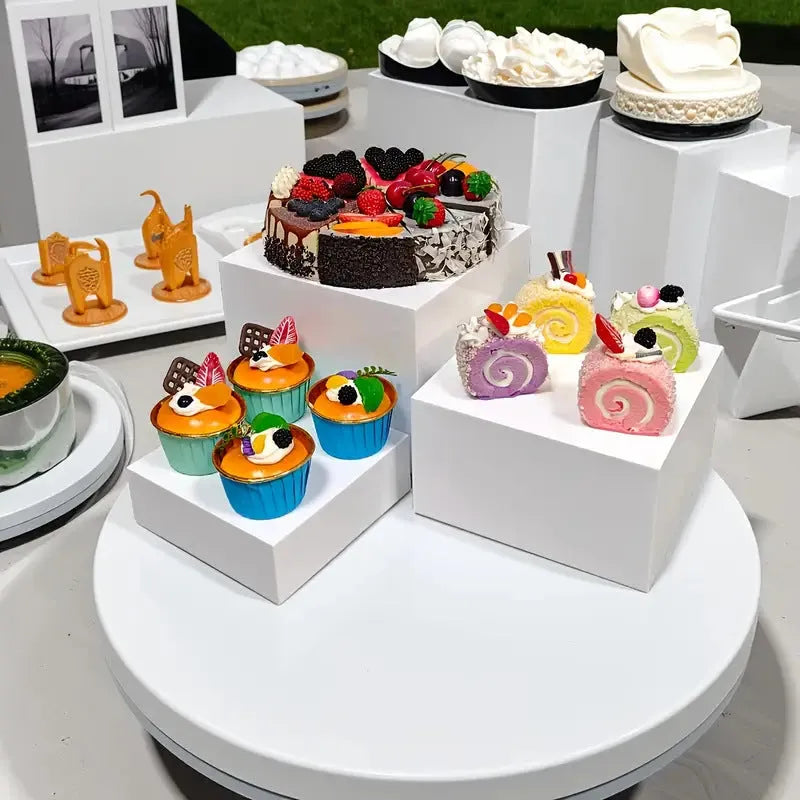 White plastic cube dessert display stand with six individual pieces for cake and confectionery presentation
