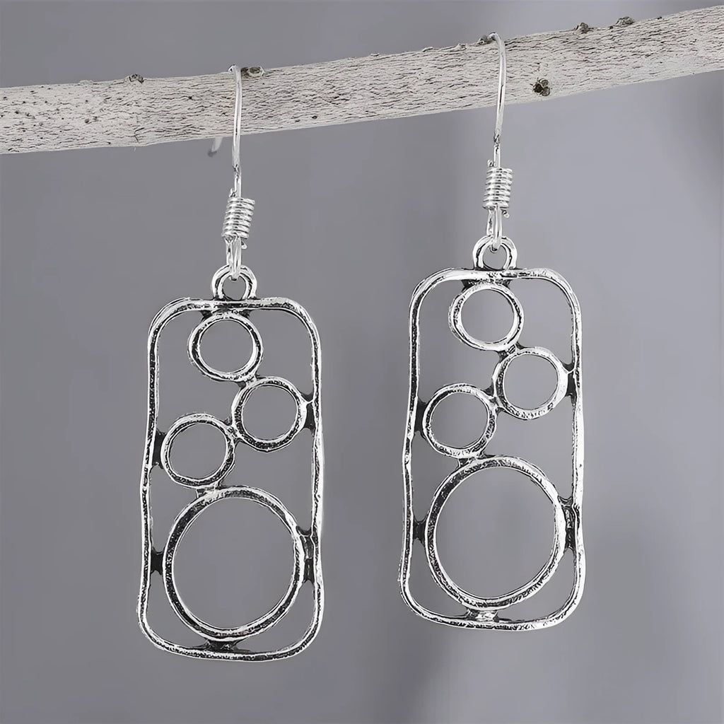A pair of antique silver round ring earrings with a geometric irregular square design.