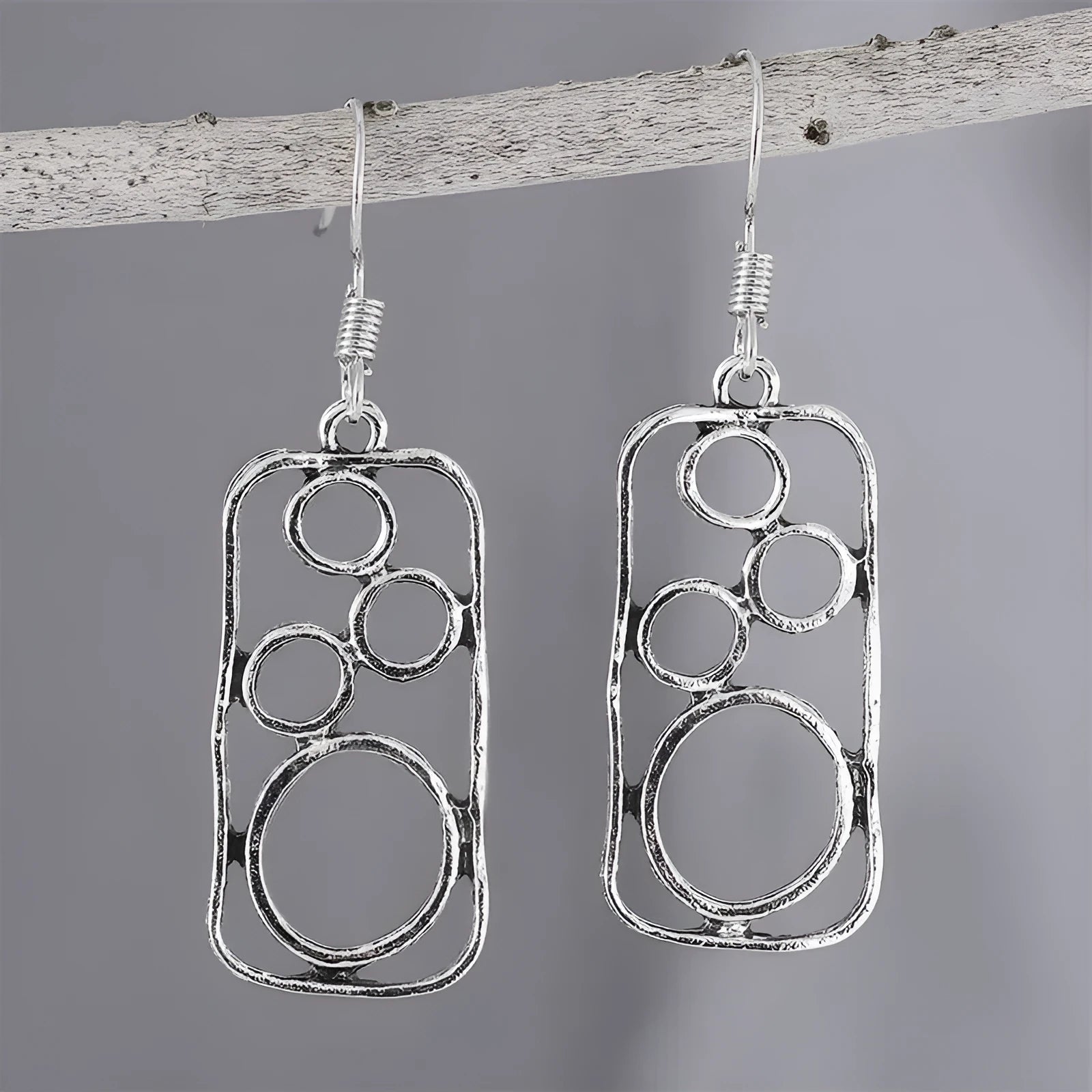A pair of antique silver round ring earrings with a geometric irregular square design.