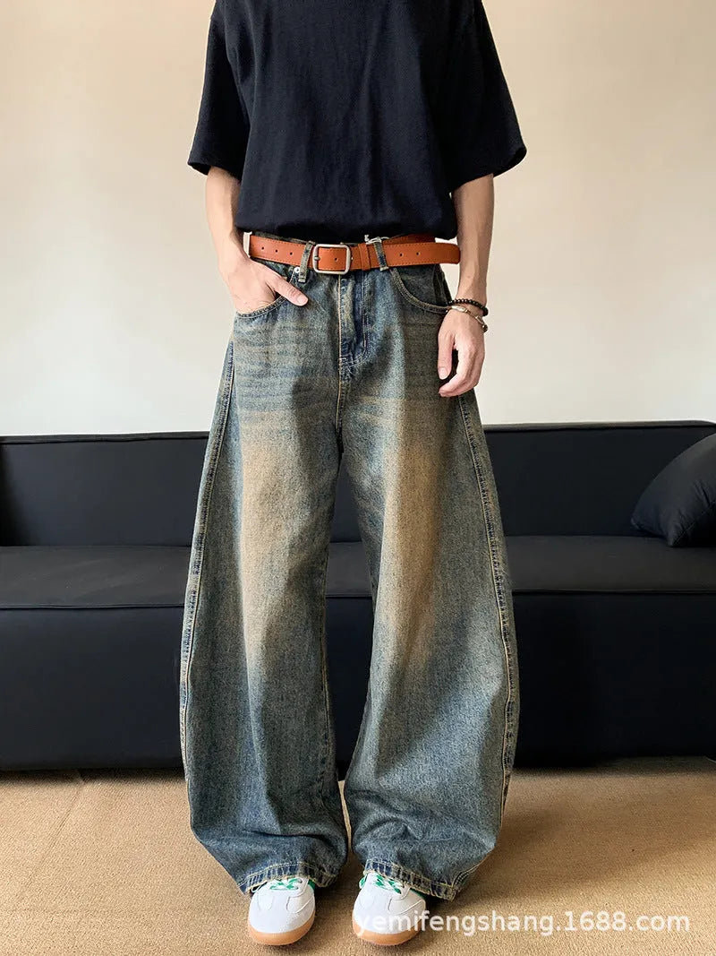 Man wearing retro blue distressed wide-leg denim jeans with a mid waist and zipper fly.
