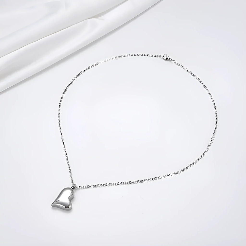Curved peach heart stainless steel pendant necklace with silver electroplated finish and extension chain