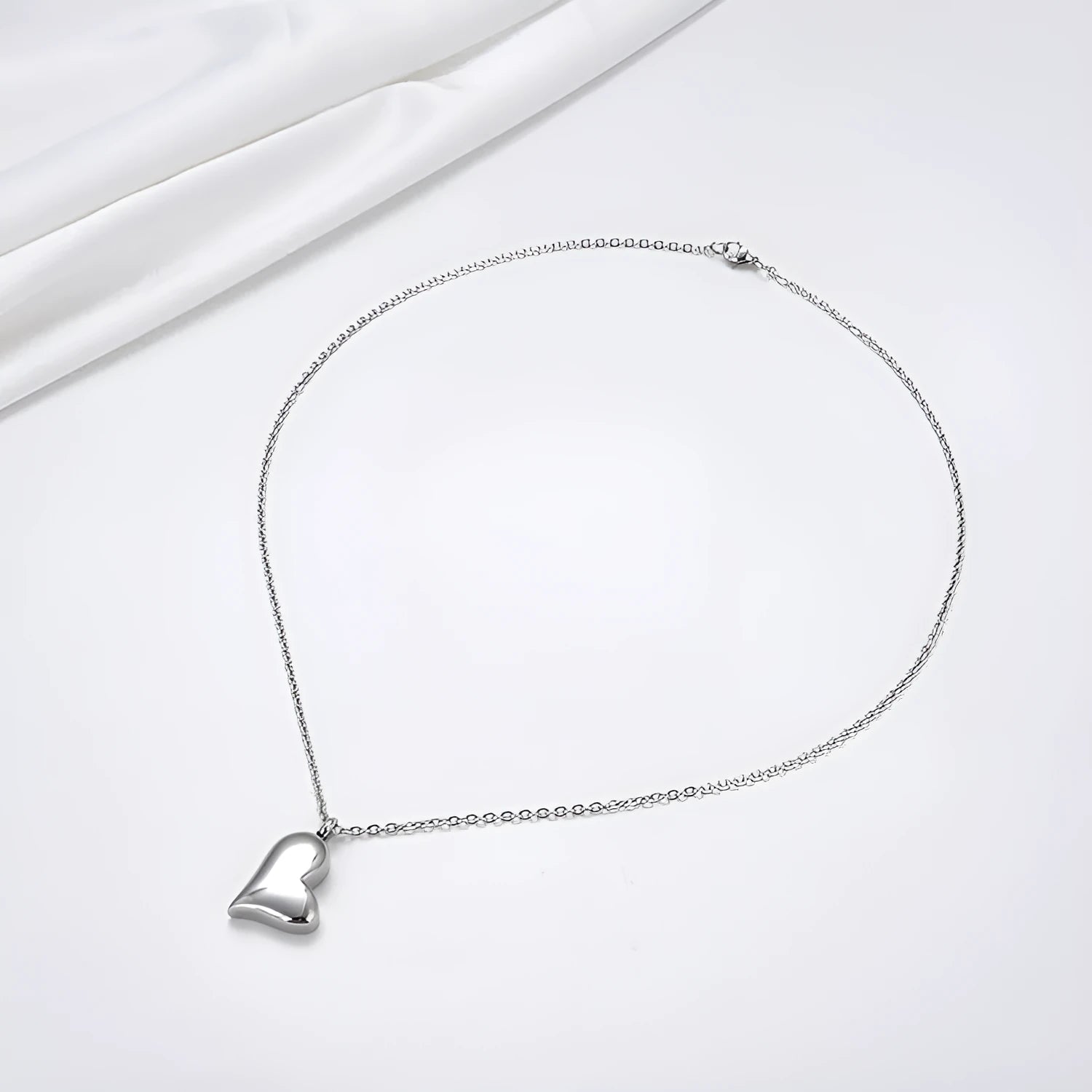 Curved peach heart stainless steel pendant necklace with silver electroplated finish and extension chain