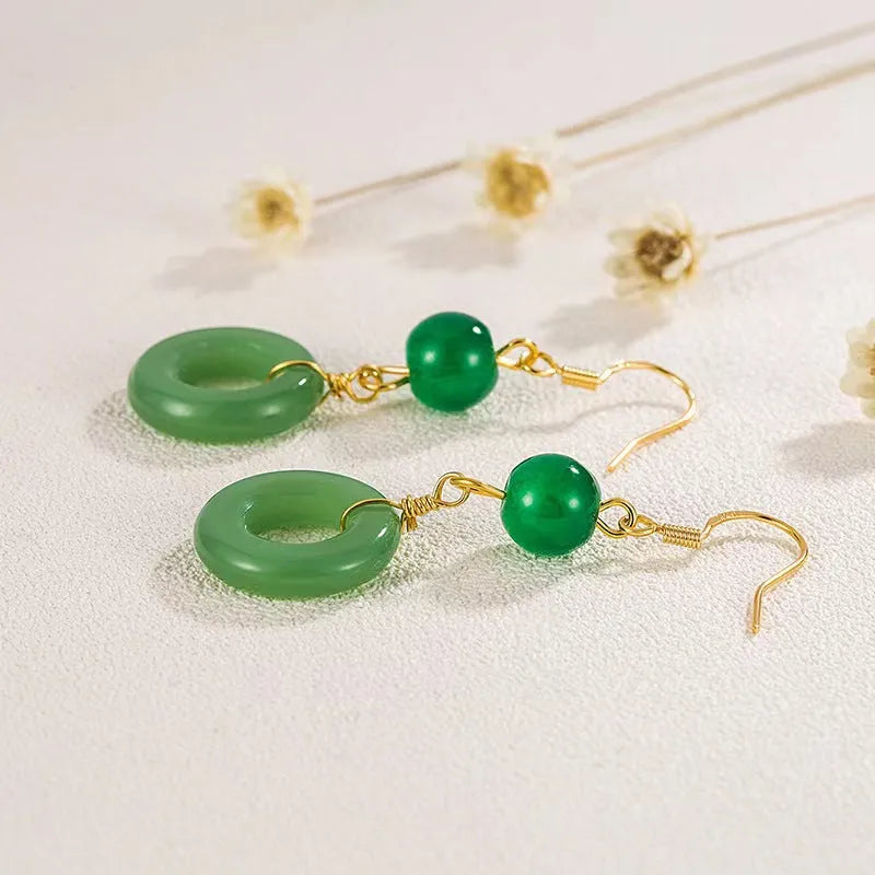 A pair of green and gold geometric earrings with a Chinese peace buckle and ring design.