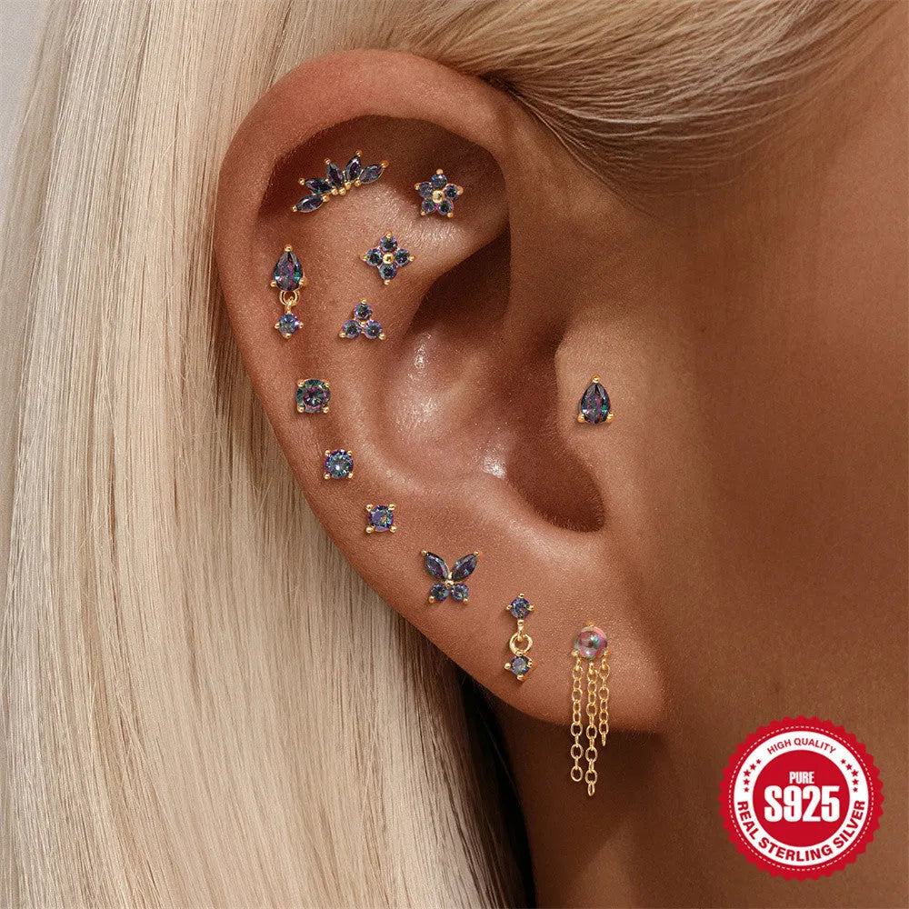S925 sterling silver flat head thread piercing with a shiny rainbow stone in a gold setting.