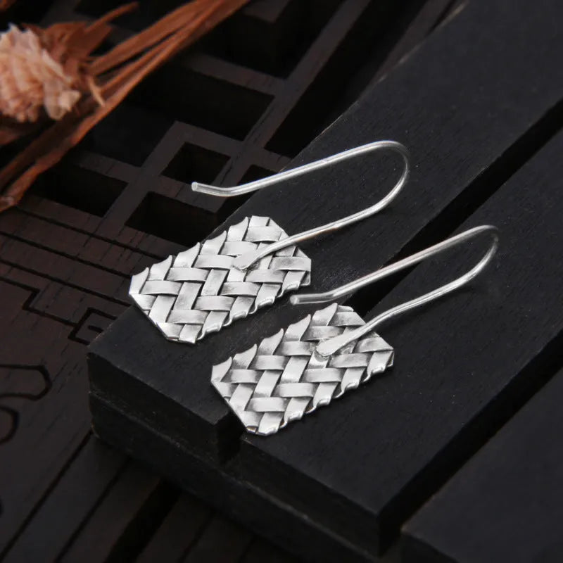 Silver geometric diamond-shaped earrings with a woven plaid pattern for women.
