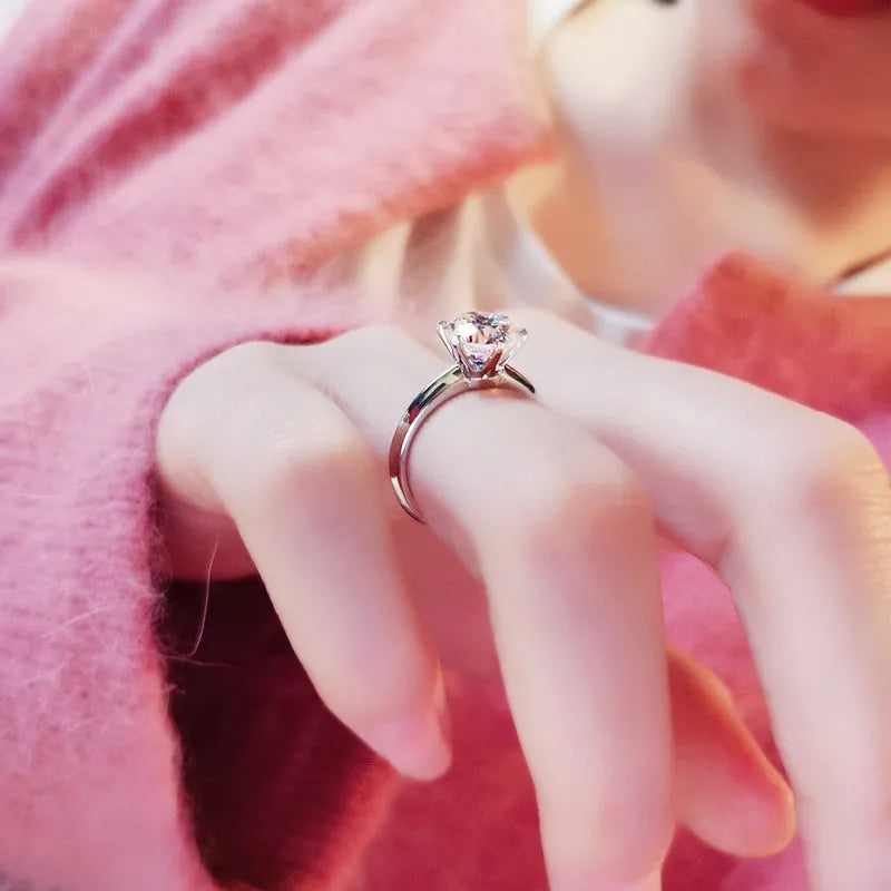 White gold-plated geometric ring with a six-claw setting holding a zircon stone.