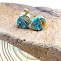Close-up of handcrafted natural stone bohemian stud earrings with irregular shape on a plain background.
