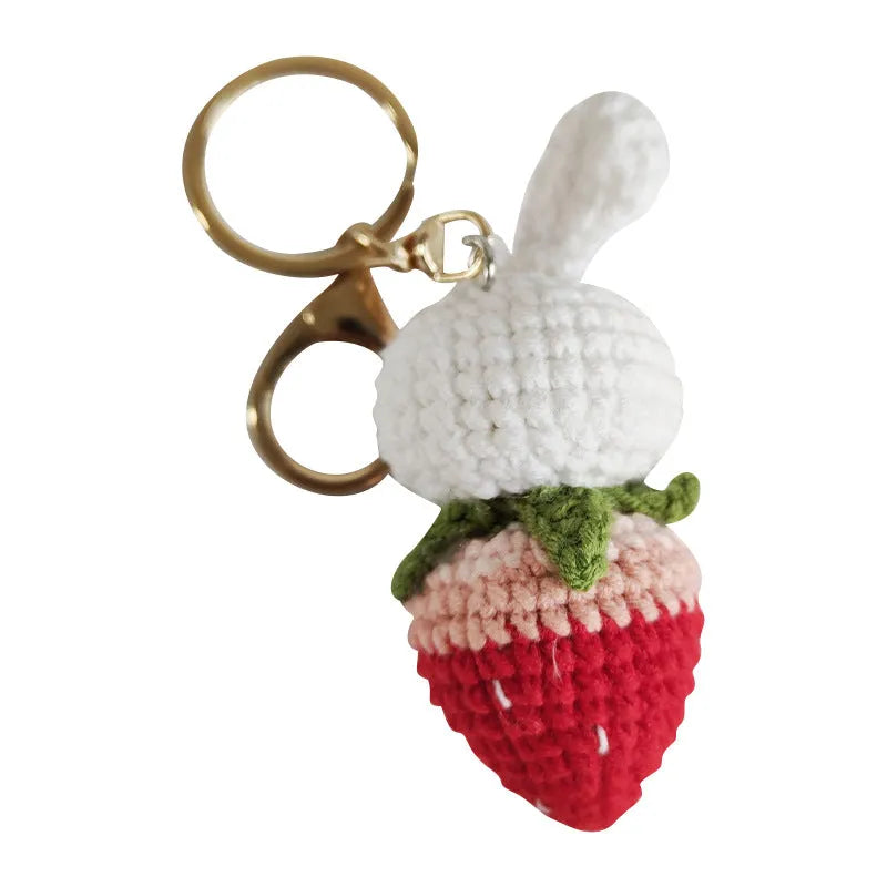 White hand-woven wire pendant with a rabbit strawberry cartoon design and a key loop.