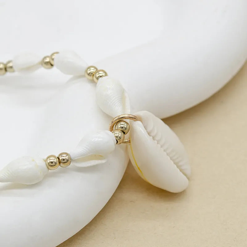 Close-up of a white conch shell bead necklace for women, showing the mother pearl shellfish pendant on a regular chain.