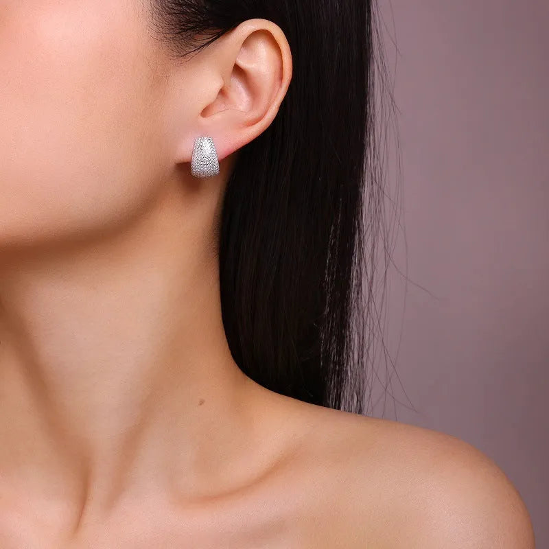 Geometric S925 sterling silver ear studs with moissanite centre on a white background.