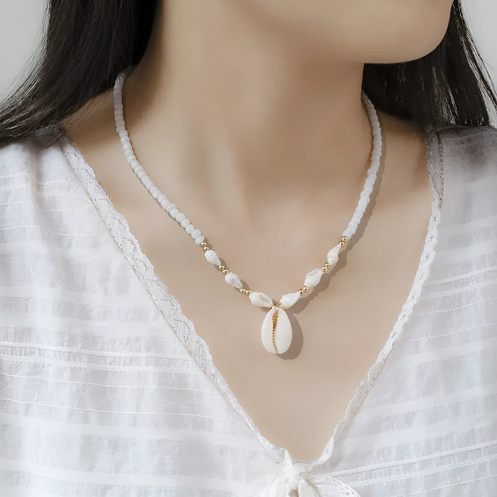Close-up of a white conch shell bead necklace for women, showing the mother pearl shellfish pendant on a regular chain.