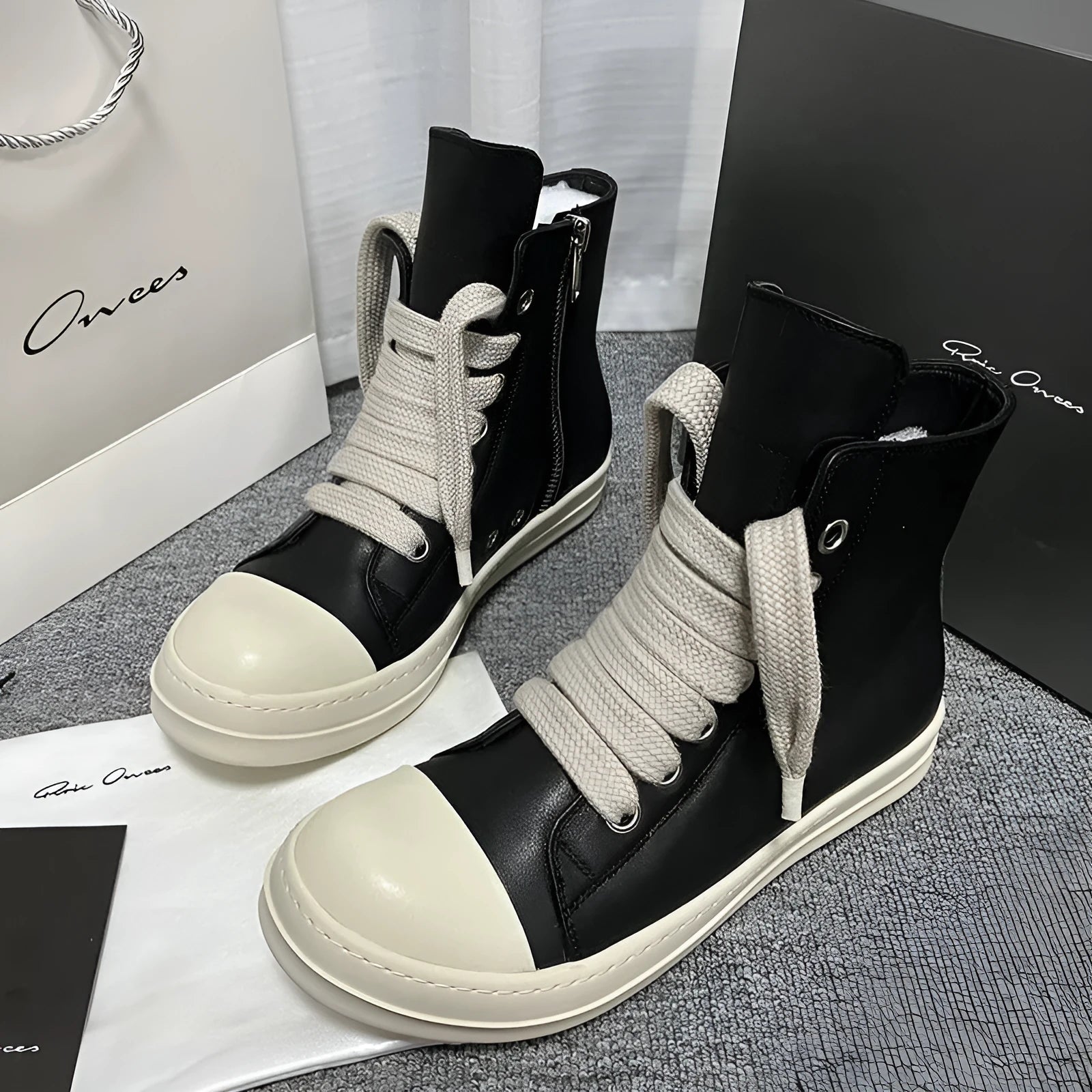 Genuine leather high-top sneakers with side zipper in black, shown on a casual outfit.