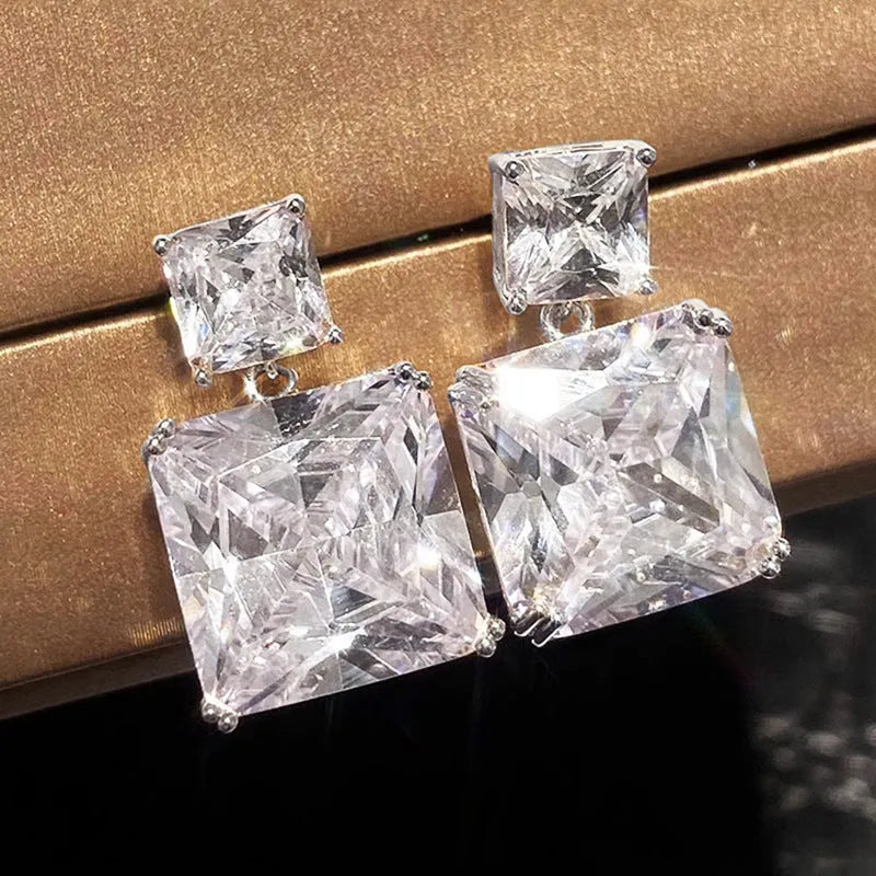 A pair of geometric square design copper earrings for women, shown in white gold and gold colour options.