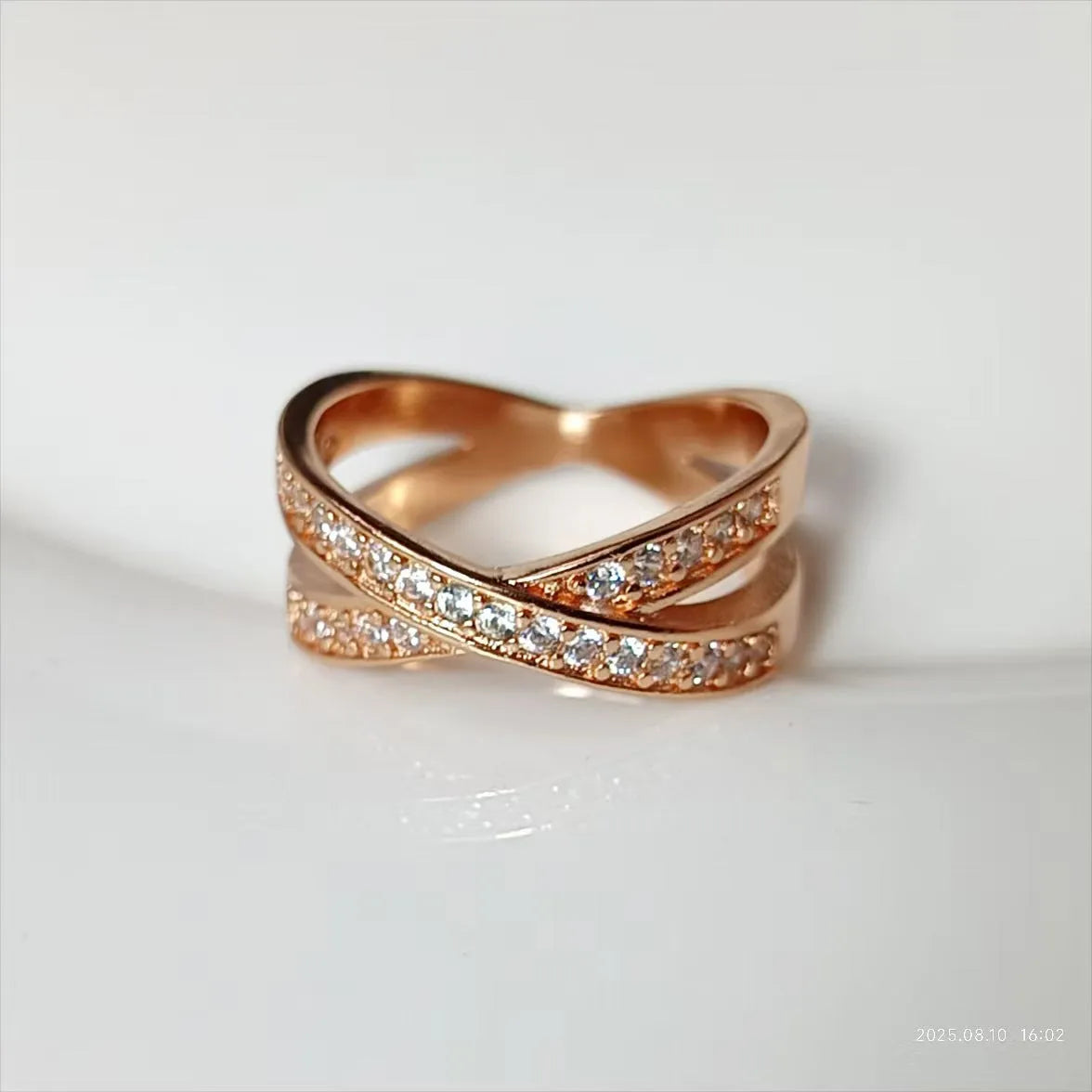 Simple geometric copper cross ring with micro-inlaid zircon stones in silver or rose gold finish.