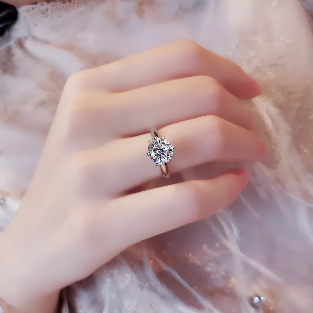 White gold-plated geometric ring with a six-claw setting holding a zircon stone.