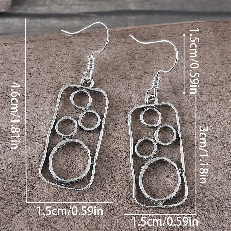 A pair of antique silver round ring earrings with a geometric irregular square design.