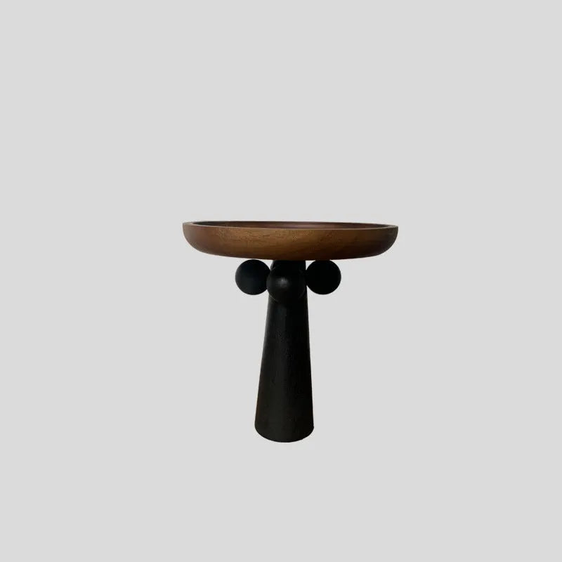 Round wooden tray with high Nordic-style legs in a light wood finish holding a candle