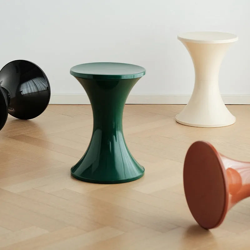 Plastic hourglass-shaped shoe changing stool shown in available colours.