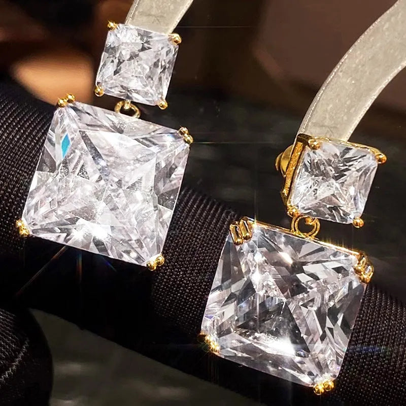 A pair of geometric square design copper earrings for women, shown in white gold and gold colour options.