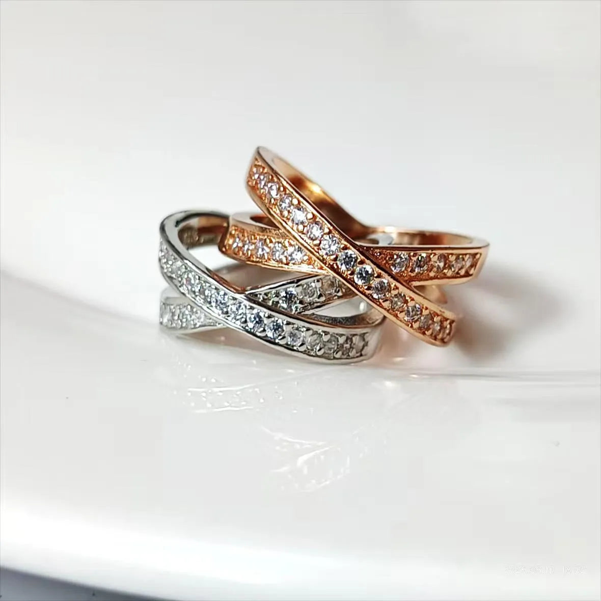Simple geometric copper cross ring with micro-inlaid zircon stones in silver or rose gold finish.