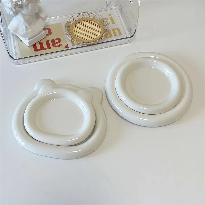 White porcelain round plate with chubby toot bear doodle pattern, shown as a plant saucer.