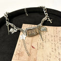 Dark electroplated women's necklace with layered chains, cross pendant, and adjustable length