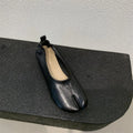 Women's black chunky heel pumps with round toe and split toe horseshoe detail