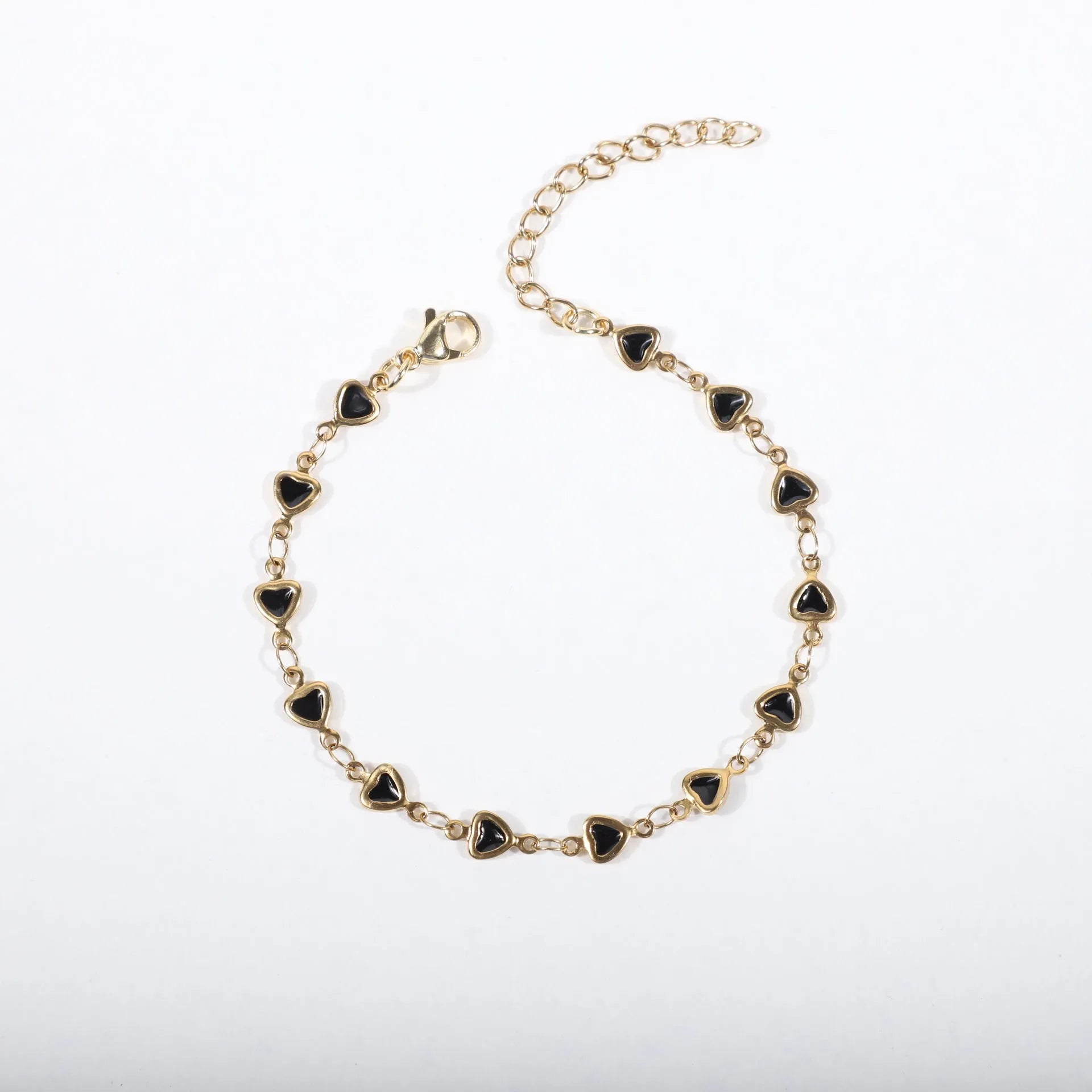 Stainless steel heart-shaped bracelet with gold plating in multiple colour options on a wrist.