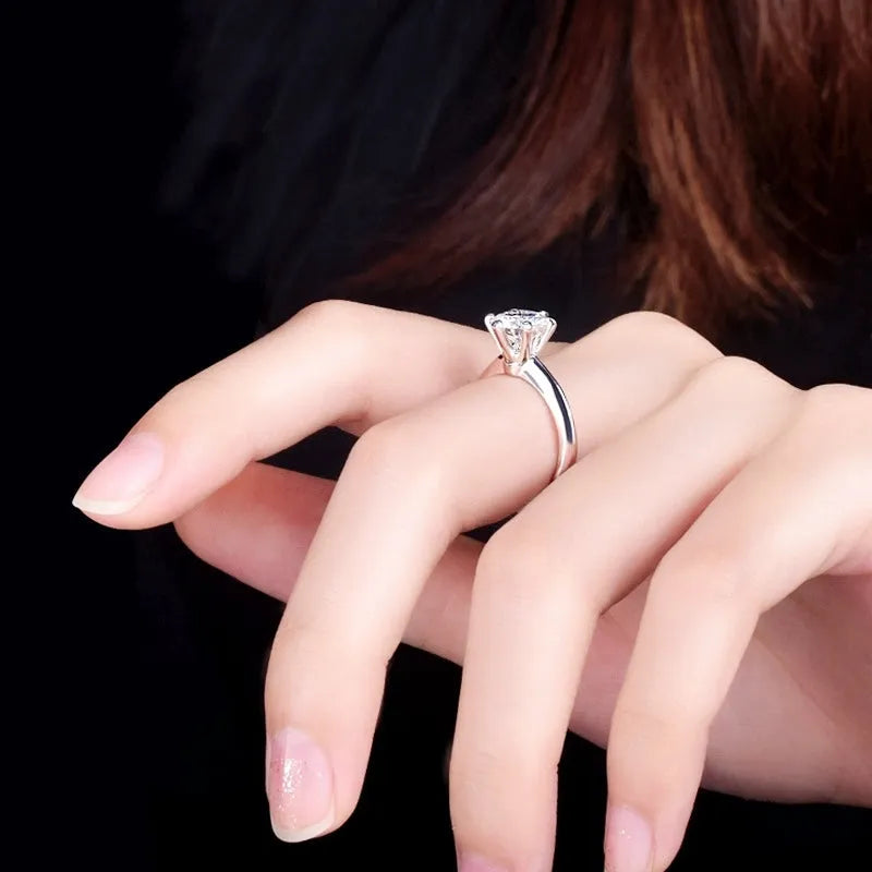 White gold-plated geometric ring with a six-claw setting holding a zircon stone.