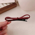 Wine red leather bow barrettes for women with handmade construction and clip mechanism