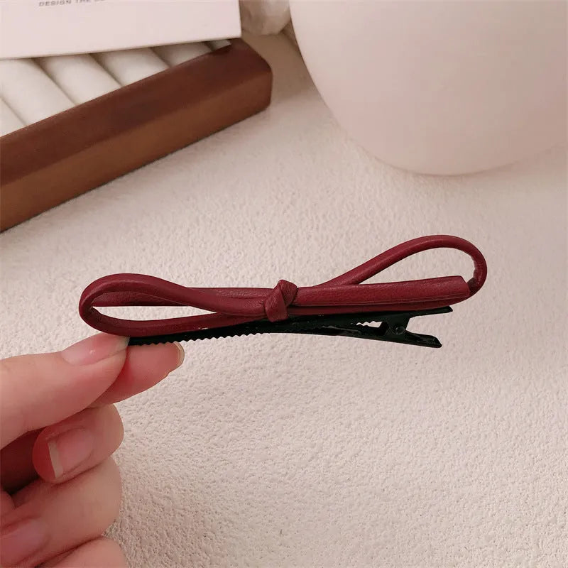 Wine red leather bow barrettes for women with handmade construction and clip mechanism