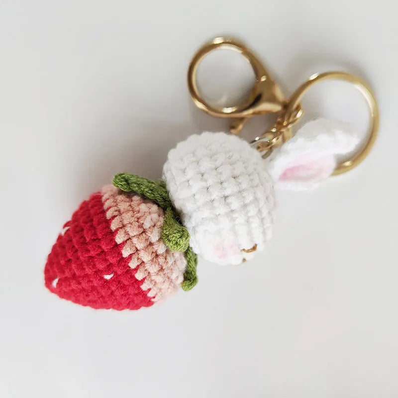 White hand-woven wire pendant with a rabbit strawberry cartoon design and a key loop.