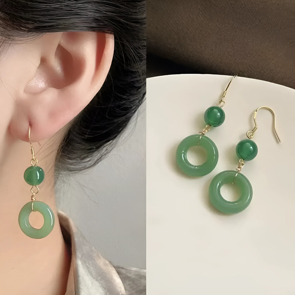 A pair of green and gold geometric earrings with a Chinese peace buckle and ring design.