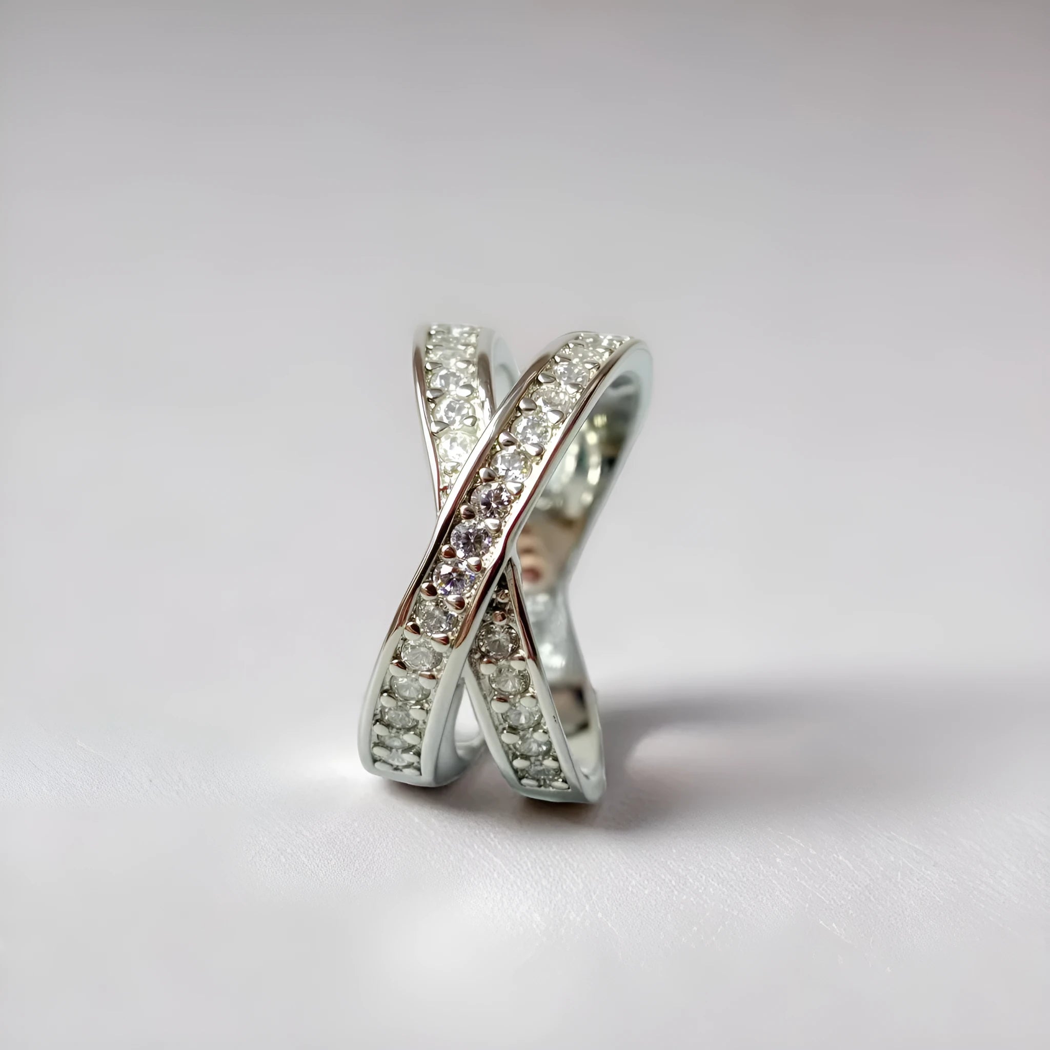 Simple geometric copper cross ring with micro-inlaid zircon stones in silver or rose gold finish.