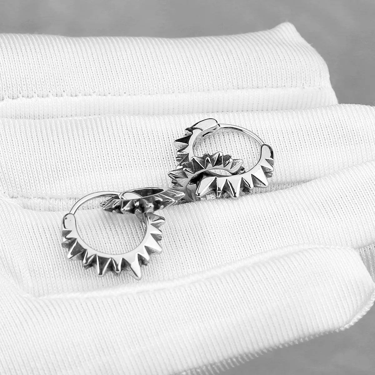 A pair of polished stainless steel round hoop earrings with a titanium steel finish in a steel colour.