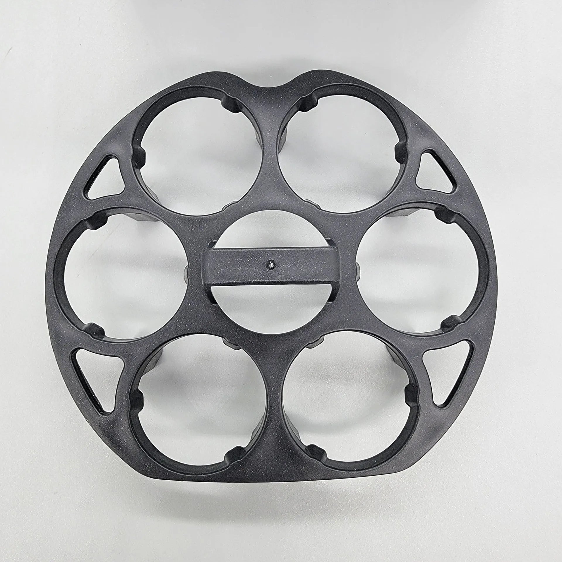 Black plastic egg holder basket rack for a cooking machine on a white background.