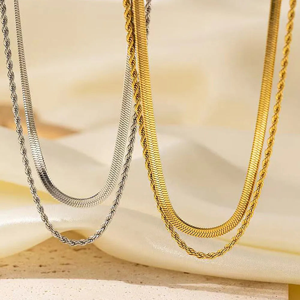 Geometric double-layer twist pendant necklace on an adjustable snake bones chain in a solid colour.